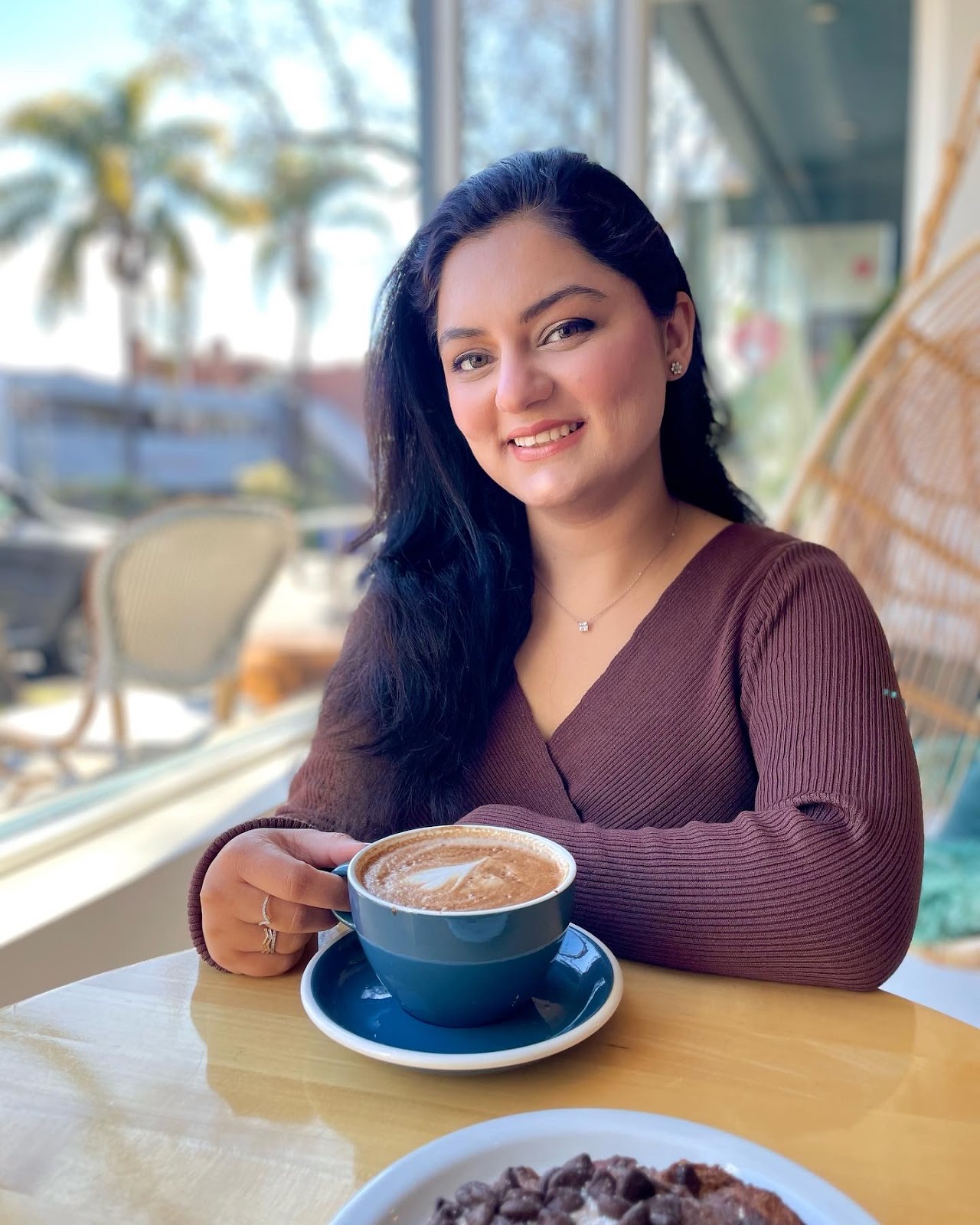 Photo of Jigyasa Grover, holding a cup of coffee, smiling